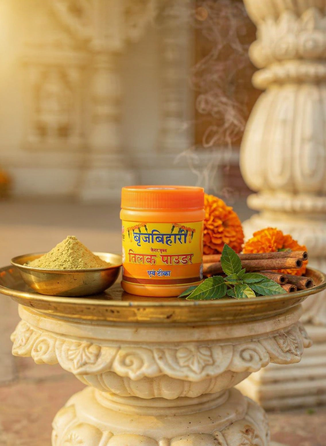 Container of 'Divine Power' on a decorative stone platform with flowers and spices, blurred background
