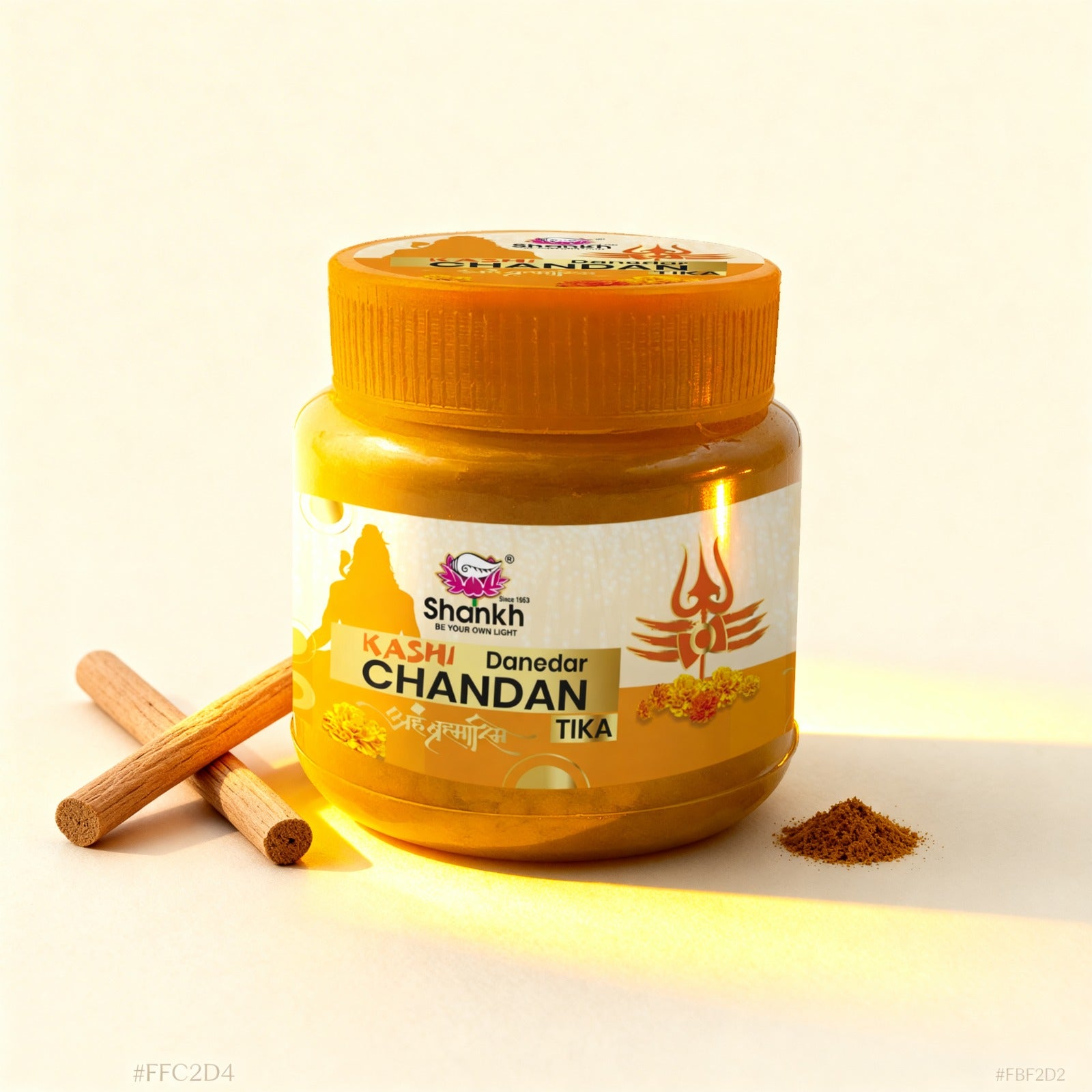 Jar of Shankh Kashi Chandan Tika with cinnamon sticks and powdered spice on a white background