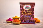 Bag of 'Scented Classic Gulal' with colorful powders and marigold flowers on a light background