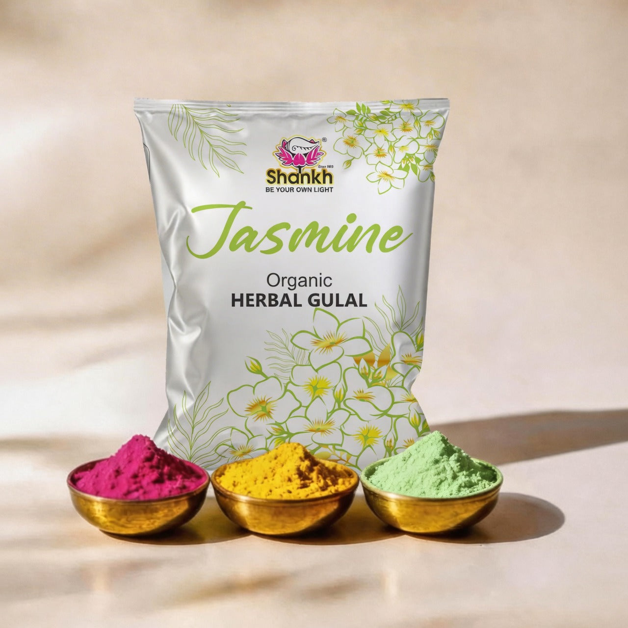 Jasmine Organic Herbal Gulal packaging with three small bowls of colored gulal on a beige background.