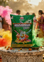 Green bag of Shankh Bal Gopala powder on a decorative stone table with colorful smoke effects in the background.