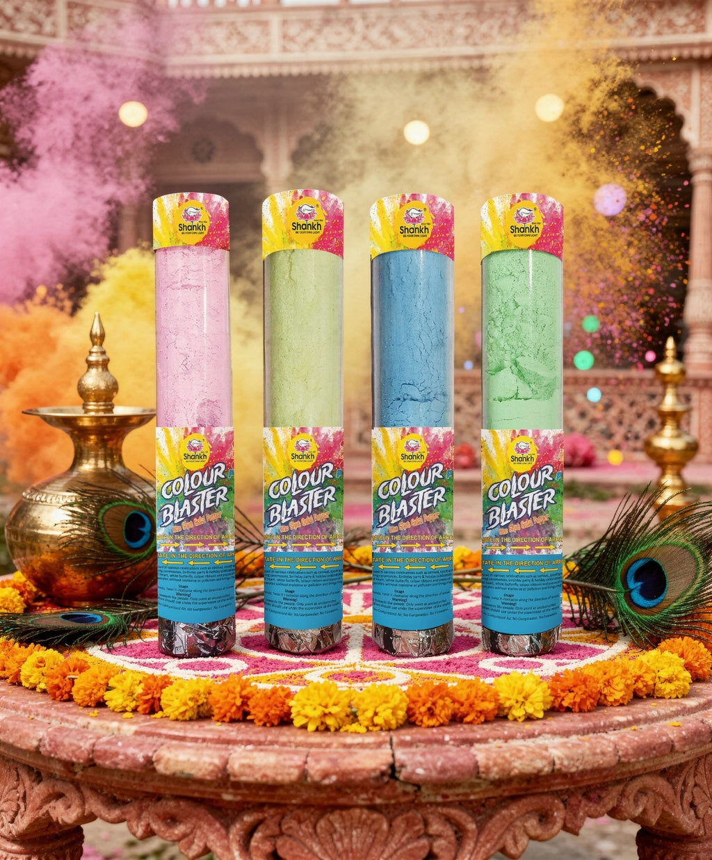 Four 'Colour Blaster' products on a decorative table with colorful confetti and peacock feathers in the background.