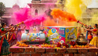 Colorful powder cans and a box on a platform with people celebrating in the background.