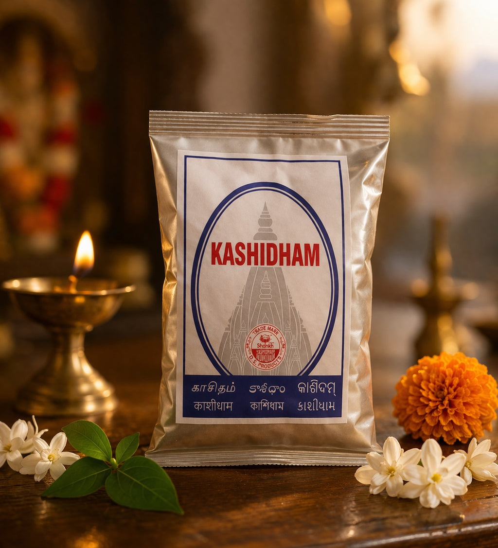 Kashidham package on a wooden surface with flowers and a lit candle in the background