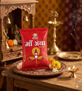 Red packet with text and a candle design on a wooden table with decorative items.