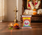 Vermilion powder packet on a wooden surface with decorative elements and a blurred background