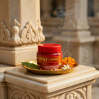 Red jar with a red lid on a decorative stone surface with flowers and leaves.