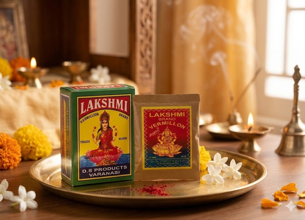 Two boxes of Lakshmi Vermillon on a decorative tray with flowers and candles in the background.
