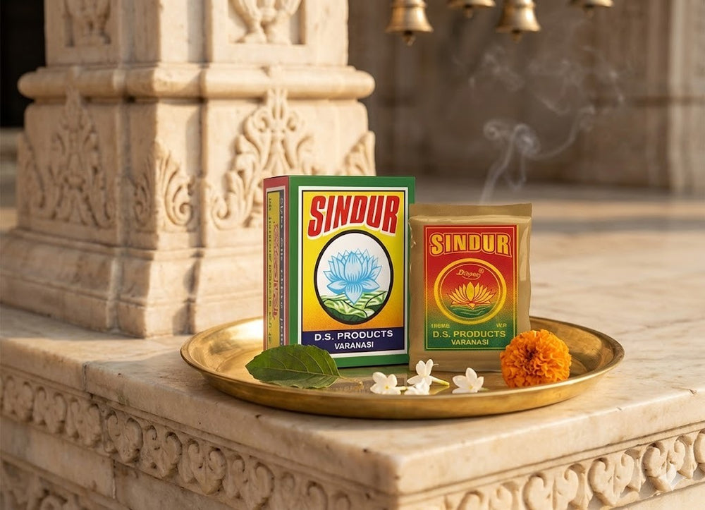 Two boxes of D.S. Products Sindur on a decorative tray with flowers and leaves, set against an ornate stone background.