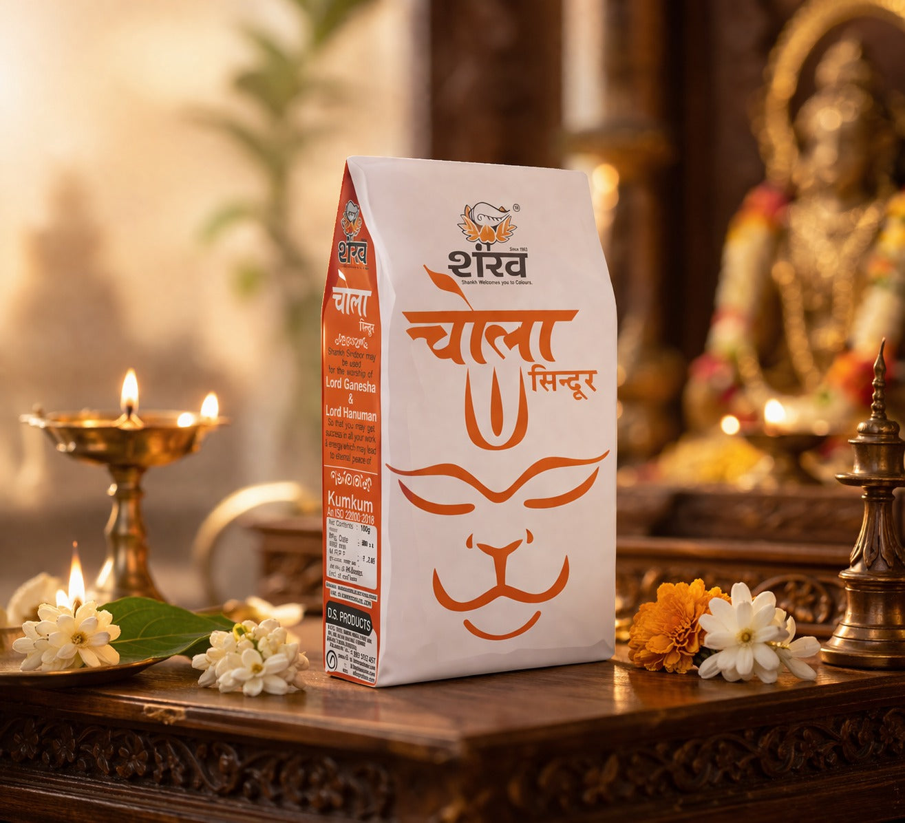 Shankar Chola Siyndur packaging on a wooden surface with flowers and a statue in the background