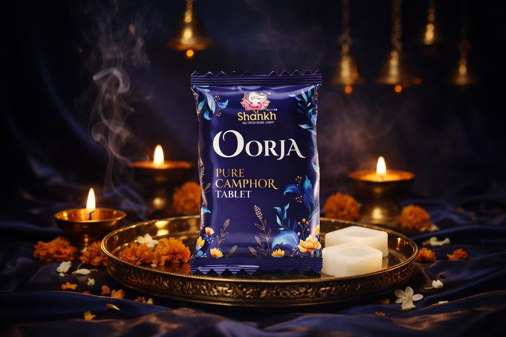 Shankh Oorja Pure Camphor Tablet packaging on a dark background with candles and flowers.