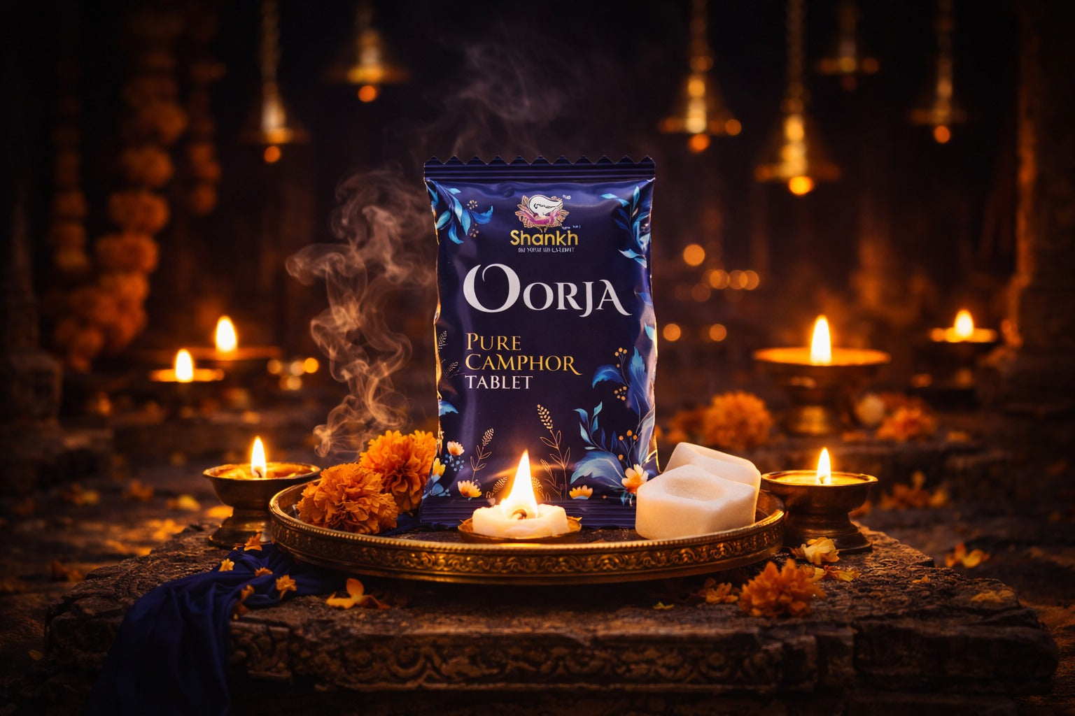 Shankh Oorja pure camphor tablet packaging on a dark background with candles and flowers.