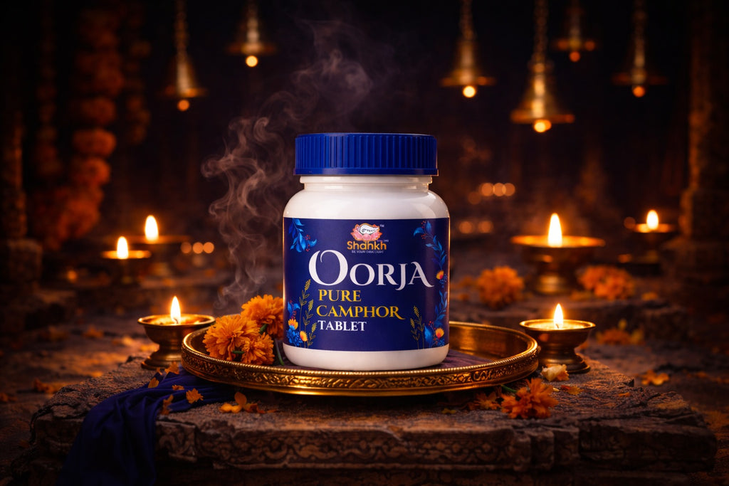 Oorja Pure Camphor Tablet container on a decorative tray with candles and flowers in the background