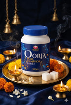 Oorja Pure Camphor Tablet container on a decorative tray with flowers and lights