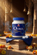 Oorja pure camphor tablet container on a decorative platform with flowers and candles.