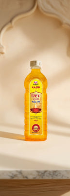 Bottle of Divya Pooja Oil on a marble surface with a decorative background