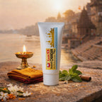 Tube of Kashi Chandan Tika with traditional elements on a stone surface with a scenic background