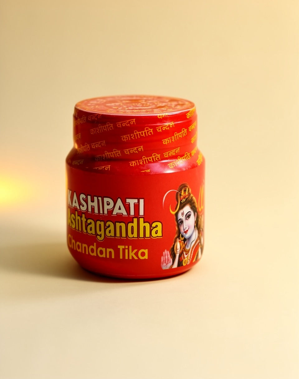 Red container of Kashipati Chandan Tika on a beige background