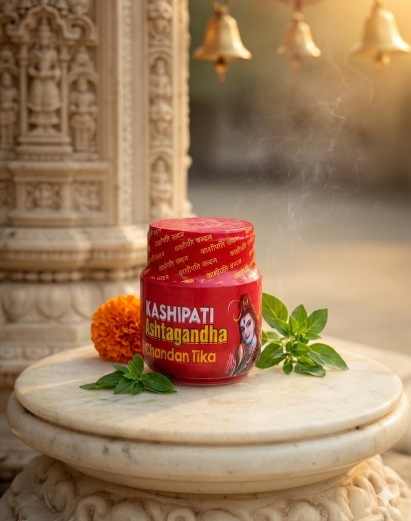 Red container labeled 'Kashipati Ashtagandha' on a marble surface with decorative elements in a temple setting.