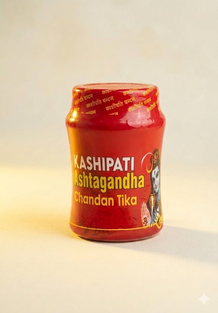 Red container of Kashipati Chandan Tika on a light background