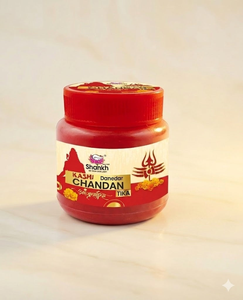 Jar of Kashi Chandan Tika with red lid on a beige background