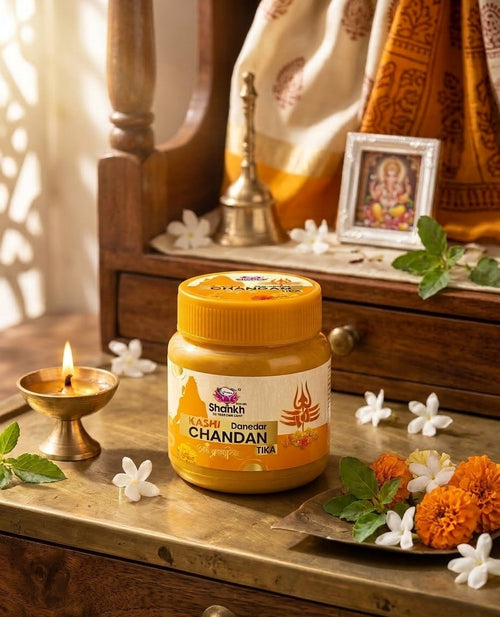 Jar of Chandan oil on a wooden surface with decorative items in the background