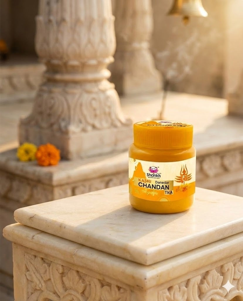 Jar of Chandan Tika on a decorative stone surface with flowers in the background